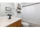 Bright bathroom featuring a wood vanity, framed mirror, and a shower with a white shower curtain at 7286 Wolff St, Westminster, CO 80030