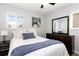 Cozy bedroom with a comfortable bed, soft lighting, and a decorative wooden mountain art piece at 7286 Wolff St, Westminster, CO 80030