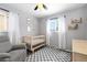 Calming Bedroom with a crib, gray recliner, natural light and a blue and white checkerboard rug at 7286 Wolff St, Westminster, CO 80030
