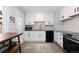 Bright kitchen featuring white cabinets, subway tile backsplash, and modern appliances at 7286 Wolff St, Westminster, CO 80030