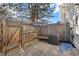 Fenced backyard patio area featuring a built-in bench, shade umbrella, and privacy fencing at 17698 E Loyola Dr # E, Aurora, CO 80013