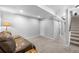 Large, carpeted basement area with natural light, closet storage, and stairway to the upper level at 17698 E Loyola Dr # E, Aurora, CO 80013