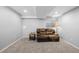 Spacious carpeted basement living area featuring a comfortable leather sofa and light, neutral paint tones at 17698 E Loyola Dr # E, Aurora, CO 80013