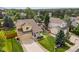 Aerial view of a home with a well-manicured lawn, inviting front porch, and mature trees at 10530 Mount Columbia Pl, Parker, CO 80138