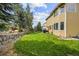Large backyard featuring a lush lawn, stone retaining wall, and mature trees providing shade at 10530 Mount Columbia Pl, Parker, CO 80138
