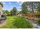 Lush backyard with a green lawn, mature trees, and a stone retaining wall, perfect for outdoor enjoyment at 10530 Mount Columbia Pl, Parker, CO 80138