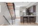 Modern kitchen with wooden cabinetry, breakfast bar, and staircase with black metal railing at 4485 Tennyson St # 5, Denver, CO 80212
