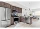 Modern kitchen featuring stainless steel appliances, wood grain cabinetry, and an open layout to the living area at 4485 Tennyson St # 5, Denver, CO 80212