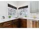 Well-lit kitchen area featuring a stainless steel sink, and modern dark wood cabinetry at 215 Locust Ln, Denver, CO 80220