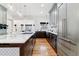 Open-concept kitchen featuring a large island, pendant lighting, modern cabinetry, and stainless appliances at 215 Locust Ln, Denver, CO 80220