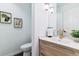 Stylish powder room with a wood vanity, white countertop, and modern gold faucet fixtures at 215 Locust Ln, Denver, CO 80220