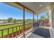 Covered balcony with wood railings and a view of the green fields at 5260 Garrison St # 11, Arvada, CO 80002