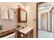 Bathroom featuring a white sink, vanity, mirror with light fixture and adjacent room at 5260 Garrison St # 11, Arvada, CO 80002