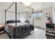 Bright bedroom features a four-poster bed, large window and neutral decor at 10550 Routt St, Westminster, CO 80021