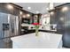 Well-lit kitchen featuring dark cabinets, stainless steel appliances, and a white countertop island at 10550 Routt St, Westminster, CO 80021