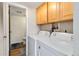 Functional laundry room with washer, dryer, ample cabinet space and a doorway to an adjacent bathroom at 10550 Routt St, Westminster, CO 80021