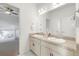 Bright bathroom featuring double sinks, granite countertop, and a view into another bedroom at 6692 S Robertsdale Way, Aurora, CO 80016