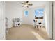 Bright, carpeted bedroom featuring a ceiling fan and large windows with play kitchen and size table and chairs at 6692 S Robertsdale Way, Aurora, CO 80016