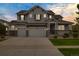 Charming two-story home with a three-car garage, well-manicured lawn, and stone accents at 6692 S Robertsdale Way, Aurora, CO 80016