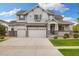 Charming two-story home with a three-car garage, well-manicured lawn, and stone accents at 6692 S Robertsdale Way, Aurora, CO 80016