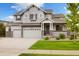 Charming two-story home with a three-car garage, well-manicured lawn, and stone accents at 6692 S Robertsdale Way, Aurora, CO 80016