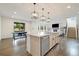 Open concept kitchen with large island, stainless steel dishwasher, and hardwood flooring at 6692 S Robertsdale Way, Aurora, CO 80016
