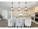 Bright kitchen with a large island, granite countertops, modern lighting, stainless appliances, and bar stool seating at 6692 S Robertsdale Way, Aurora, CO 80016