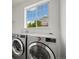 Well-lit laundry room with modern front load washer and dryer at 6692 S Robertsdale Way, Aurora, CO 80016