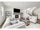 Bright living room boasts a fireplace, large windows, hardwood floors, and modern staircase at 6692 S Robertsdale Way, Aurora, CO 80016