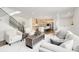 Open-concept living room with a view into the kitchen, featuring a modern staircase and comfortable seating at 6692 S Robertsdale Way, Aurora, CO 80016
