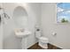 Clean powder room featuring a pedestal sink, toilet, dark wood floors, and a window at 6692 S Robertsdale Way, Aurora, CO 80016