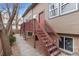 Multi-level home with dark wood stairs and red door; landscaped with river rock at 6450 W 44Th Pl # B3, Wheat Ridge, CO 80033
