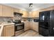 The kitchen features wooden cabinets, a mosaic backsplash, and stainless steel appliances at 6450 W 44Th Pl # B3, Wheat Ridge, CO 80033