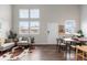 Open-plan living room with high ceilings, large windows, modern furnishings, and wood floors at 6450 W 44Th Pl # B3, Wheat Ridge, CO 80033