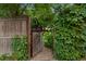 Rustic wooden gate with iron detailing offers entry to lush, private backyard at 1960 Hudson St, Denver, CO 80220