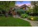 Beautiful backyard featuring a stone patio, pergola, manicured lawn, and lush greenery at 1960 Hudson St, Denver, CO 80220