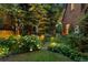 Lush backyard featuring mature trees, garden beds and exterior lighting for evening enjoyment at 1960 Hudson St, Denver, CO 80220