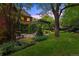 Scenic backyard showcasing a lush lawn, brick patio, pergola, and mature landscaping at 1960 Hudson St, Denver, CO 80220