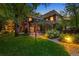 Inviting backyard with a lush lawn, brick patio, pergola, and mature landscaping with exterior lighting at 1960 Hudson St, Denver, CO 80220