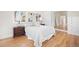 Airy bedroom featuring a hardwood floor, a bed with neutral bedding, two windows, and two lamps at 1960 Hudson St, Denver, CO 80220
