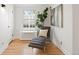 Bright bedroom with a modern lounge chair, hardwood floors and neutral walls with natural sunlight at 1960 Hudson St, Denver, CO 80220