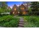 Stately brick home featuring professional landscaping, mature trees, and a charming stone walkway at 1960 Hudson St, Denver, CO 80220