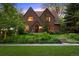 Charming brick two-story home with lush landscaping and mature trees providing curb appeal at 1960 Hudson St, Denver, CO 80220