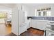 Charming kitchen with stainless steel refrigerator, white cabinetry, and colorful tiling at 1960 Hudson St, Denver, CO 80220