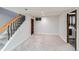 Carpeted basement featuring open stairs, egress window, storage and laundry room at 15756 E Temple Pl, Aurora, CO 80015