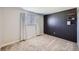 Minimalist bedroom featuring carpeted floors, a dark accent wall with built-in shelves, and large window at 15756 E Temple Pl, Aurora, CO 80015