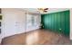 Bright living room featuring hardwood floors, a stylish accent wall, and a ceiling fan, creating a welcoming space at 15756 E Temple Pl, Aurora, CO 80015