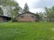 The property features a backyard with grass and minimal landscaping behind a brick home at 1890 Eaton St, Lakewood, CO 80214