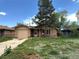 Charming single-story home with brick exterior, lawn, and mature trees in a residential neighborhood at 1890 Eaton St, Lakewood, CO 80214