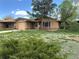 Charming single-story home with brick exterior, lawn, and mature trees in a residential neighborhood at 1890 Eaton St, Lakewood, CO 80214
